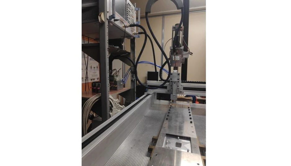 TU Wien: What waves know about their surroundings - Experimental setup to measure the information transport via microwaves at Université Côte d’Azur. (Nice). On the table, one can see a waveguide into which an electromagnetic signal is injected (blue cables in the background). Inside the waveguide are Teflon objects (white cylinders in the foreground) that scatter the signal. This creates a complex wave field, which was measured at various points to determine the flow of information about the horizontal position of the metallic cuboid in the foreground.